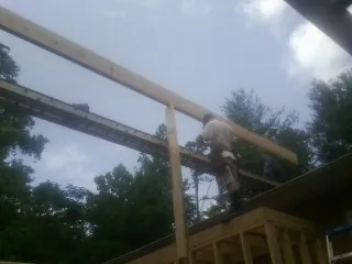Carpenter setting a ridge beam over a new addition frame — Ice Dam Removal by Roofing Brothers in Cammal