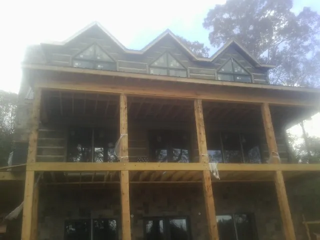 Dormers and porch framing on a large log home under construction — Roof Coating work by our crew in Cammal