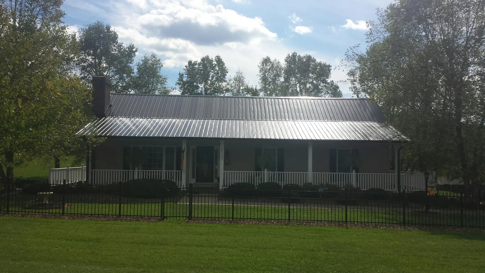 Gray metal roof on a brick ranch with a full width front porch — Gutter Guard Installation work by our crew in Cammal