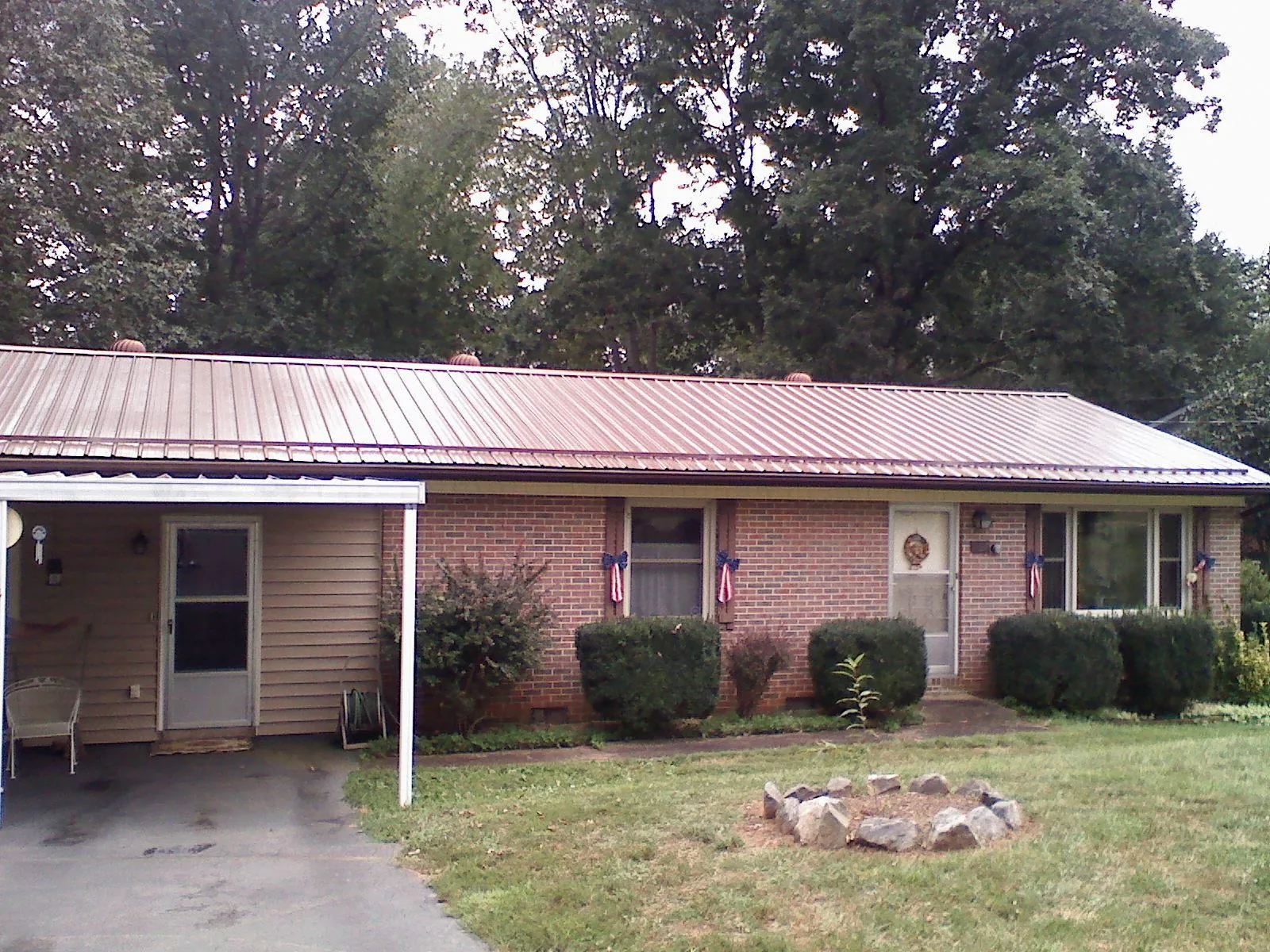 Bronze metal roof and carport on a brick ranch home — Roof Repair work by our crew in Cammal
